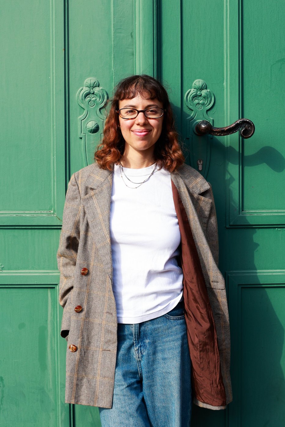 Mica sonriendo frente a una puerta verde